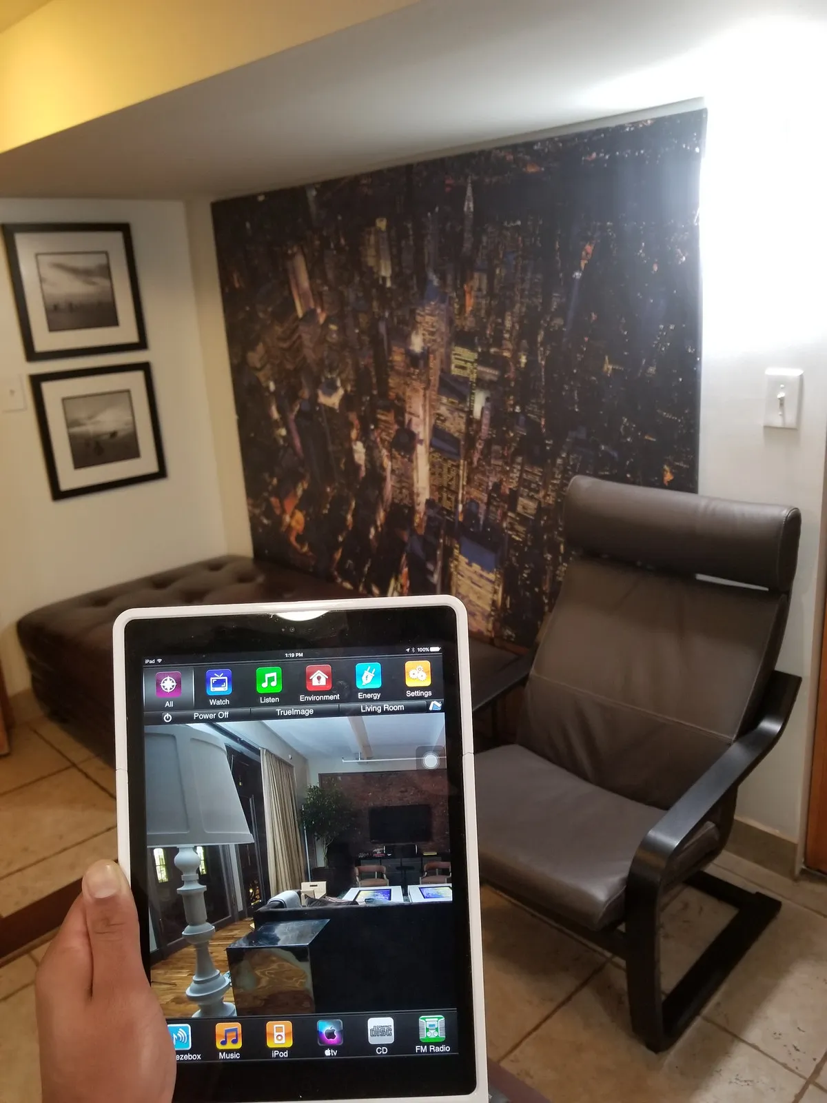 A tablet running a home control app showing zones for watching, listening, environment, and energy.